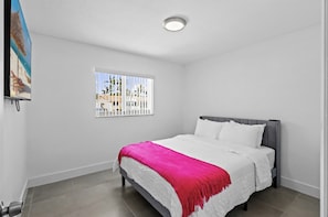 Ein Schlafzimmer mit einem Bett, einem Fenster mit Blick und einer Deckenleuchte.