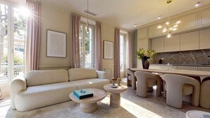 Una sala moderna con sofá, una mesa de centro y un comedor con sillas.