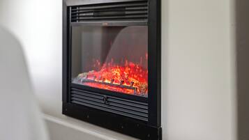 Ein an der Wand befestigter Kamin mit sichtbarem Feuer.
