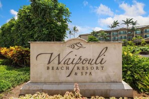A sign for Waipouli Beach Resort & Spa with a stone base and decorative elements. - A/C Luxury Poolside Retreat / Resort fee included (Kapaʻa)