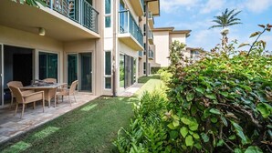 A residential building with a patio area, a dining table, and chairs. - A/C Luxury Poolside Retreat / Resort fee included (Kapaʻa)