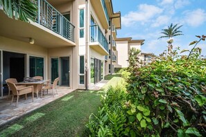 A residential building with a patio area, a dining table, and chairs. - A/C Luxury Poolside Retreat / Resort fee included (Kapaʻa)