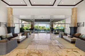 A spacious lobby with a central seating area, large windows, and a view of the outdoors. - Waipouli C102 / 2 King Beds / AC  / Pool (Kapaʻa)