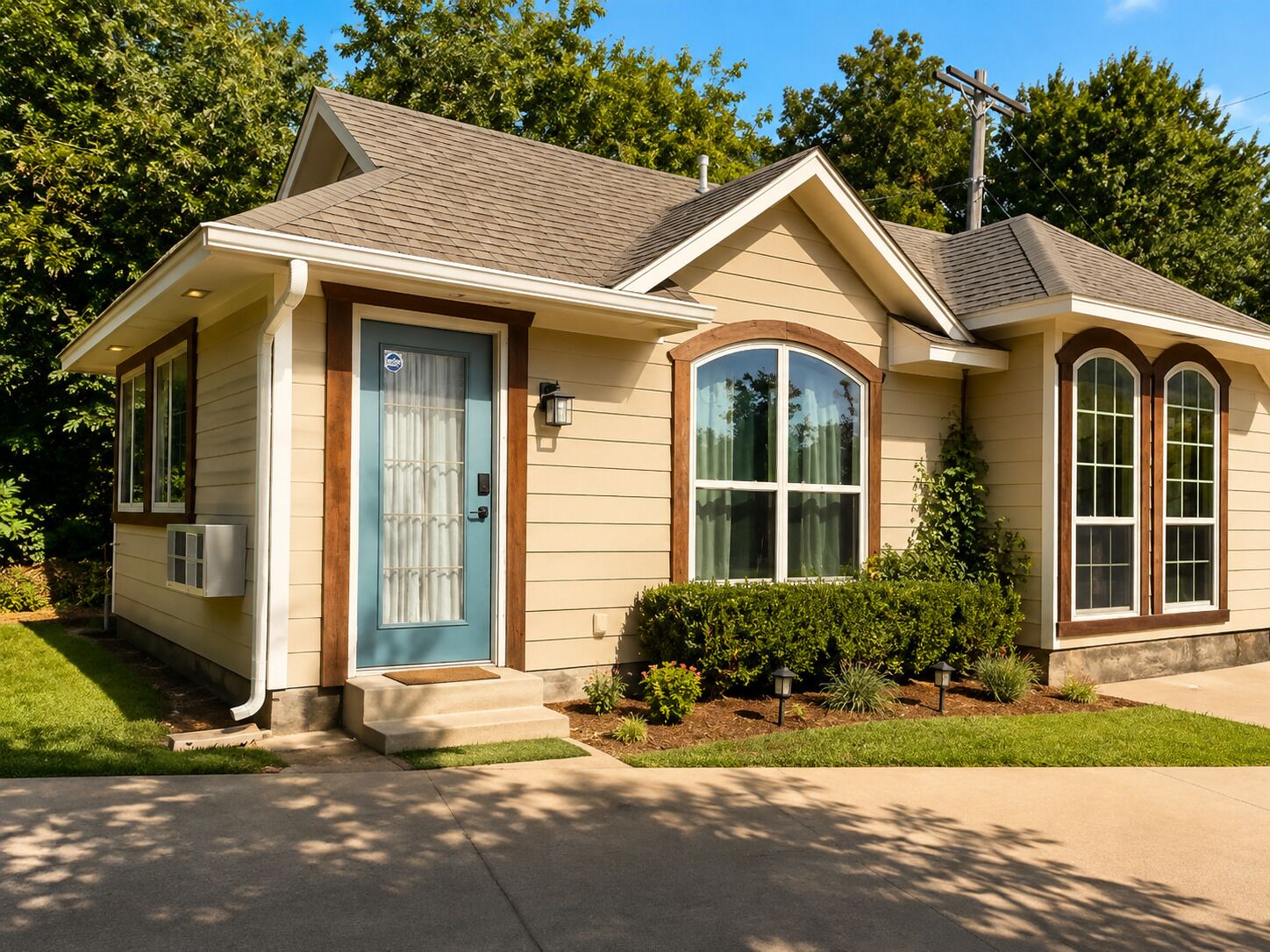 A single-story house with a front porch, a blue door, and a small front yard.