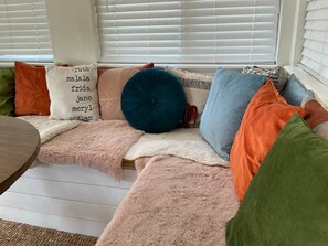 A cozy seating area with a variety of pillows and a fluffy blanket. - OKC 1 Bed 1 Bath Mini Guesthouse - The Margot (Oklahoma City)