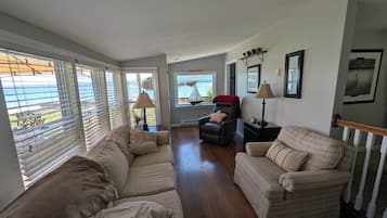 Una sala de estar con vista al lago, un sofá, un sillón reclinable y una lámpara.