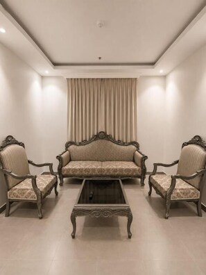 Una habitación con un sofá, dos sillones y una mesa de centro.