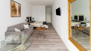 A modern, well-lit room with a glass coffee table, a sofa, a bed, and a large mirror. - La Aparecida Tourist Lodging, set in a natural setting with fabulous views. (Ampuero)