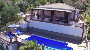 A two-story house with a swimming pool, a balcony, and a car parked nearby. - Casa Miranda Cómpeta by Ruralidays (Málaga)