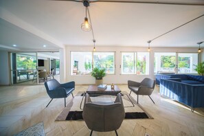 A spacious living area with a sofa set, a coffee table, and a dining table. - The Garden Mansion | 11 bedrooms with a club lounge•Jacuzzi•Olympic Pool•Cleaning Lady•Air Conditioning (Medellín)
