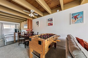 A room with a foosball table, a sofa, a ceiling fan, and wall art. - Tahoe Keys Studio Retreat - HOA Amenities (South Lake Tahoe)