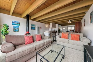 A modern living room with a herringbone-patterned sofa, a glass coffee table, and a fireplace. - Tahoe Keys Studio Retreat - HOA Amenities (South Lake Tahoe)