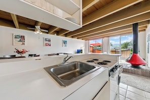 A modern kitchen with a stainless steel sink, a stove, and a ceiling fan. - Tahoe Keys Studio Retreat - HOA Amenities (South Lake Tahoe)