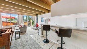 Une cuisine moderne avec un coin bar, une cheminée et une vue sur l’extérieur.