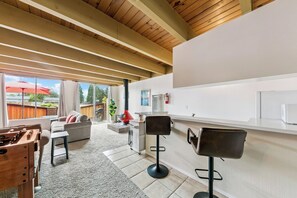 A modern kitchen with a bar area, a fireplace, and a view of the outdoors. - Tahoe Keys Studio Retreat - HOA Amenities (South Lake Tahoe)