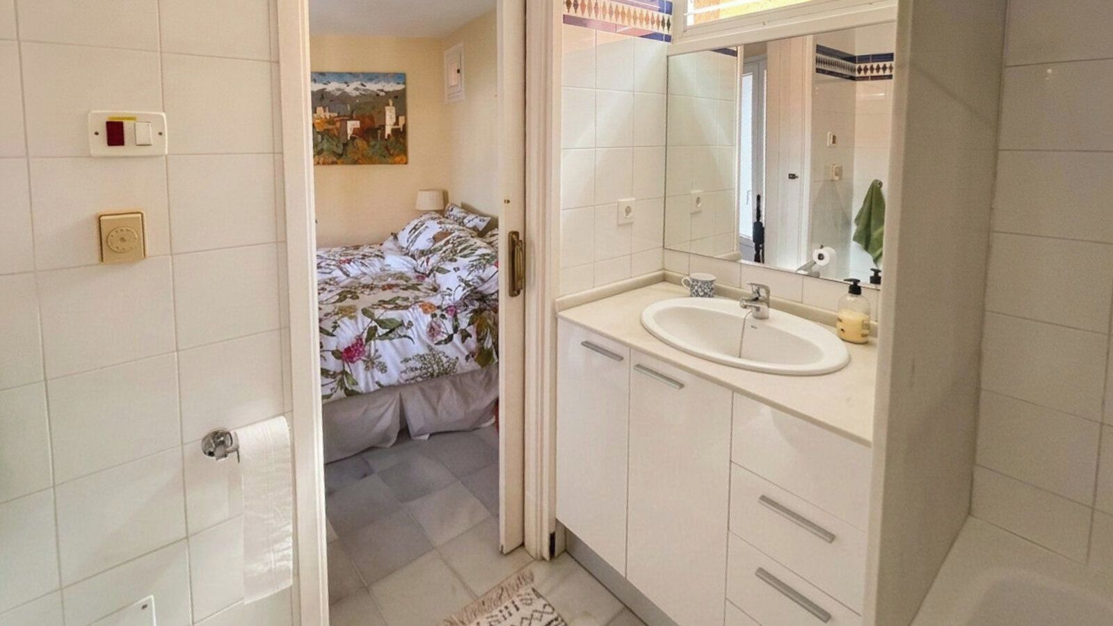 Une salle de bain avec un lavabo, un miroir et des toilettes.