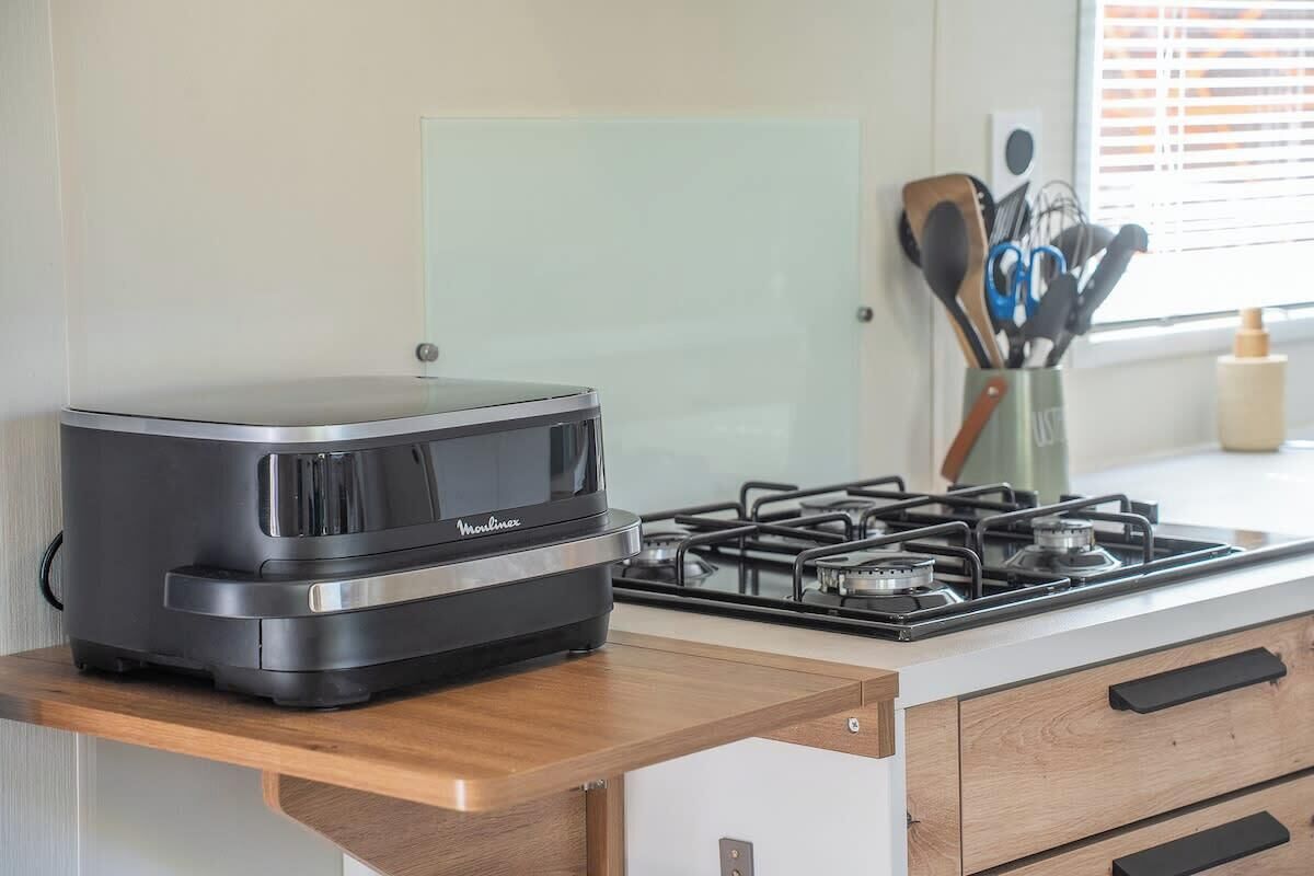 Una cocina moderna con estufa integrada, una encimera y un armario.