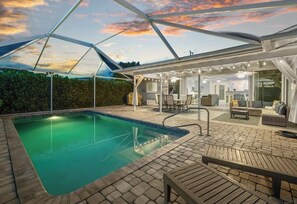 A pool area with a covered patio, seating, and a view of the sky. - Pool, Sunsets and Water Access! 3-bedroom house in lovely Cape Coral (Cape Coral)