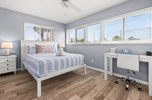 A bedroom with a bed, bedside tables, a desk, and a ceiling fan. - Pool, Sunsets and Water Access! 3-bedroom house in lovely Cape Coral (Cape Coral)