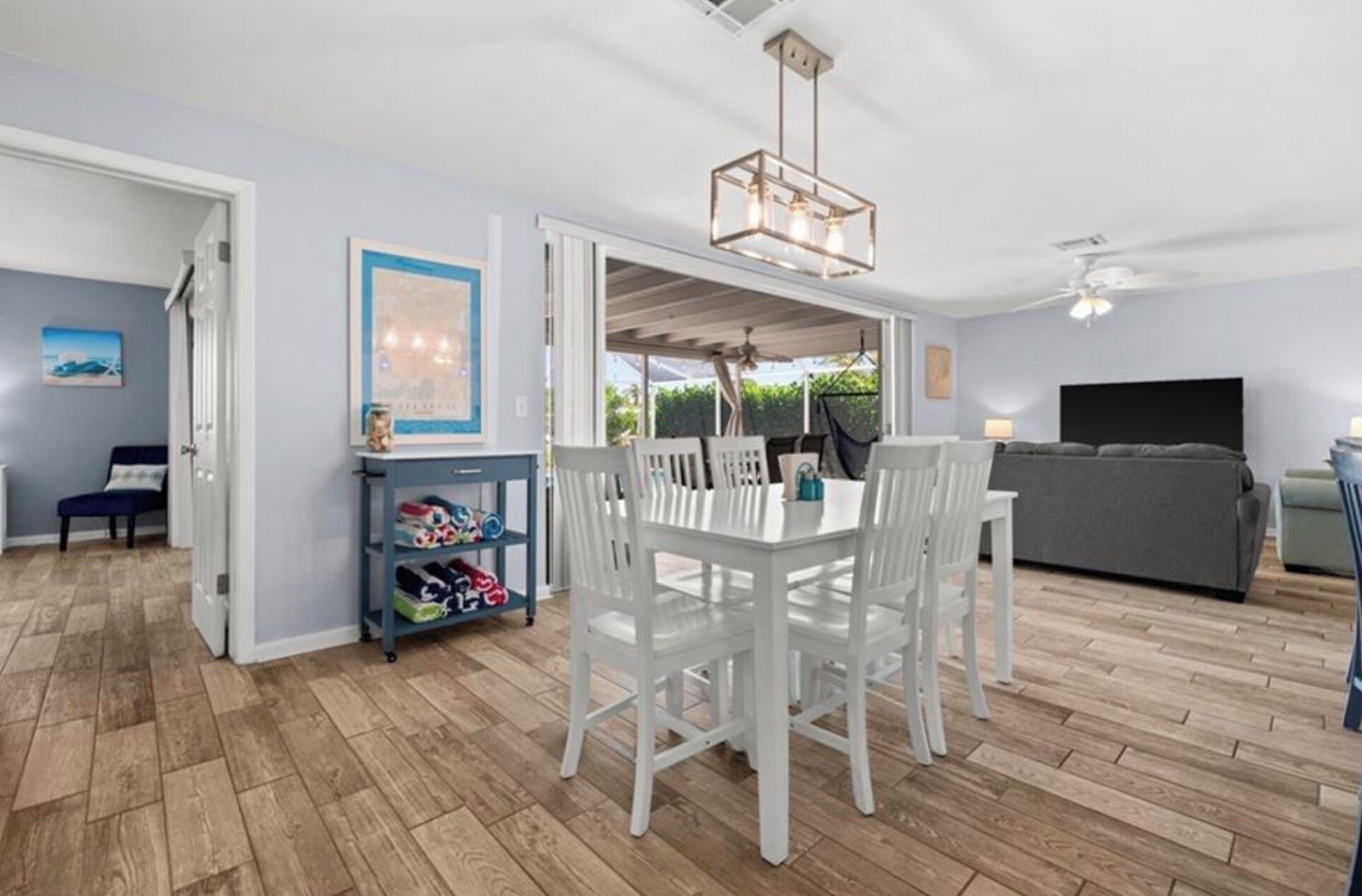 Una habitación con una mesa de comedor, sillas, un sofá y un televisor.