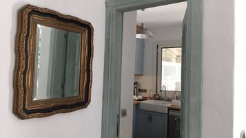 A kitchen with a sink, cabinets, and a mirror with an ornate frame.