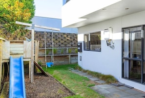 A modern outdoor play area with a slide, a swing, and a climbing structure. - Harvey Heights Retreat (Taupō)