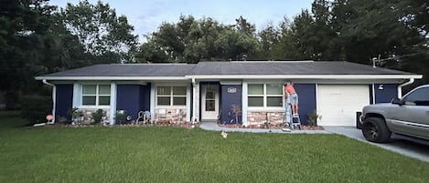 A single-story house with a garage, a front lawn, and a parked vehicle.