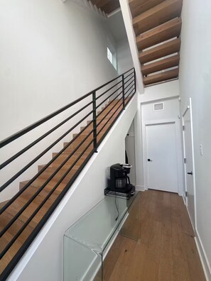 Eine Treppe mit einem Glastisch und einer Kaffeemaschine auf der Zwischenebene.