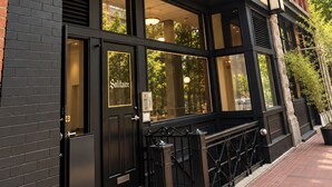 A building facade with a black and red brick exterior, large windows, and a sign that reads 'Solitaire.' - The Solitaire Hotel (Vancouver)