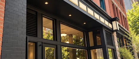 A building facade with a black and red brick exterior, large windows, and a sign that reads 'Solitaire.'