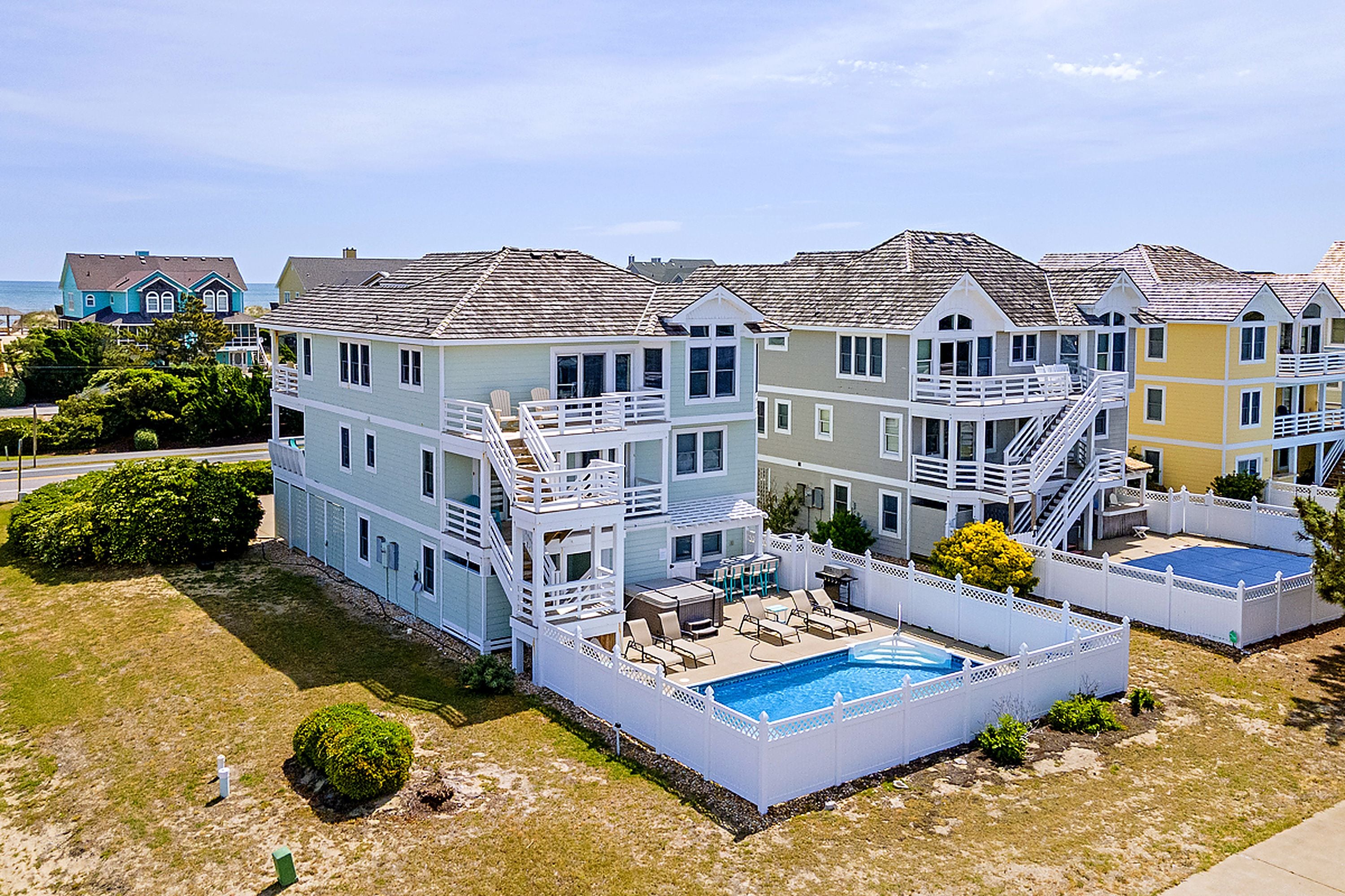 A multi-story residential building with a swimming pool and outdoor seating area.