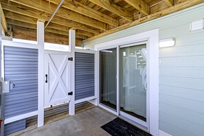 A covered outdoor area with a wooden ceiling, a sliding door, and a glass door leading to a covered porch. - 🏖️ Luxury 8BR🌊 Ocean Views💦 Free Pool Heat♨️ Elevator🐾2nd Row✨Pet Friendly (Nagshead)