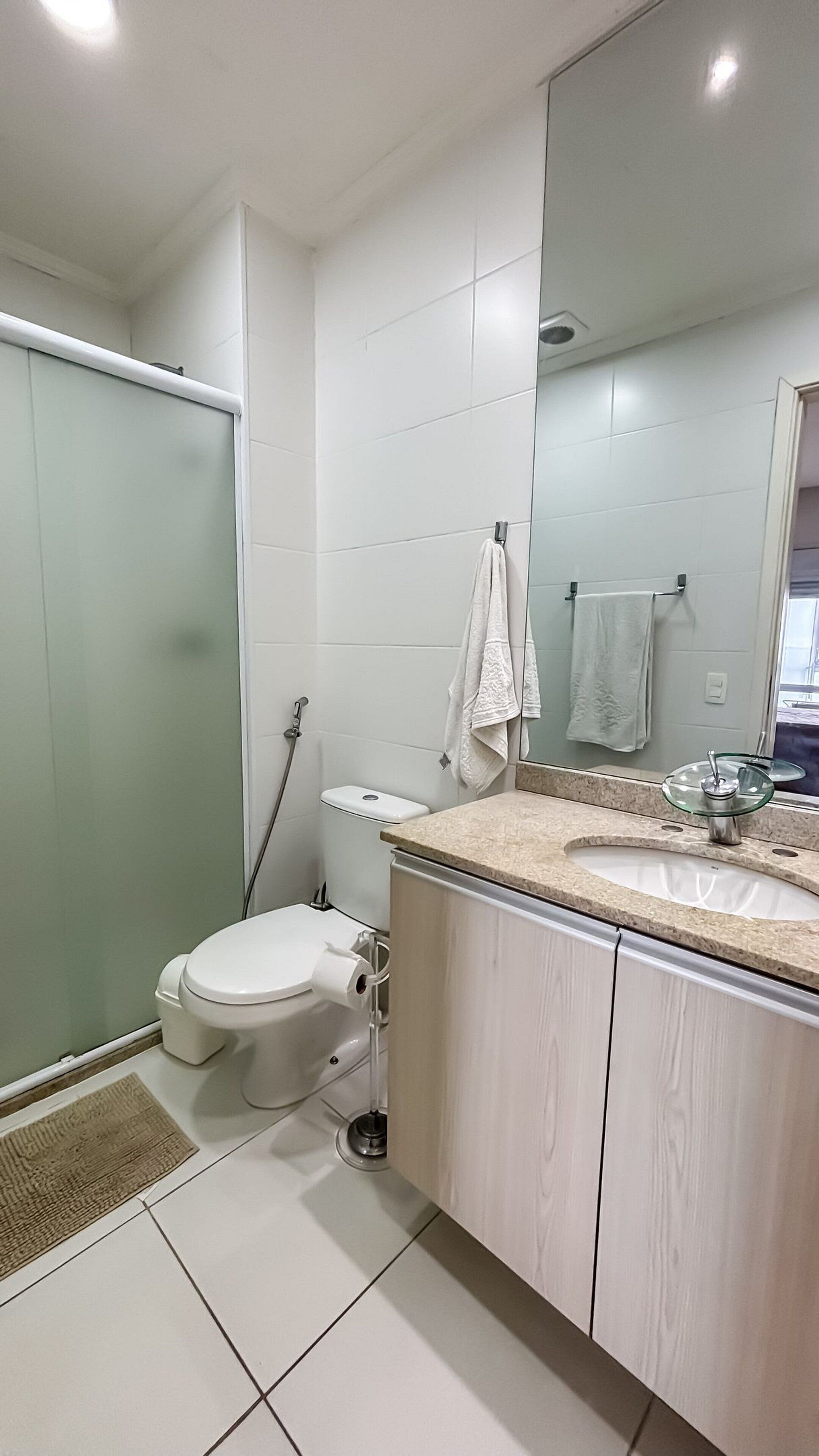 Un baño moderno con inodoro, lavamanos y ducha.
