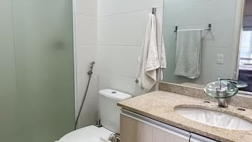 Un baño moderno con inodoro, lavamanos y ducha.