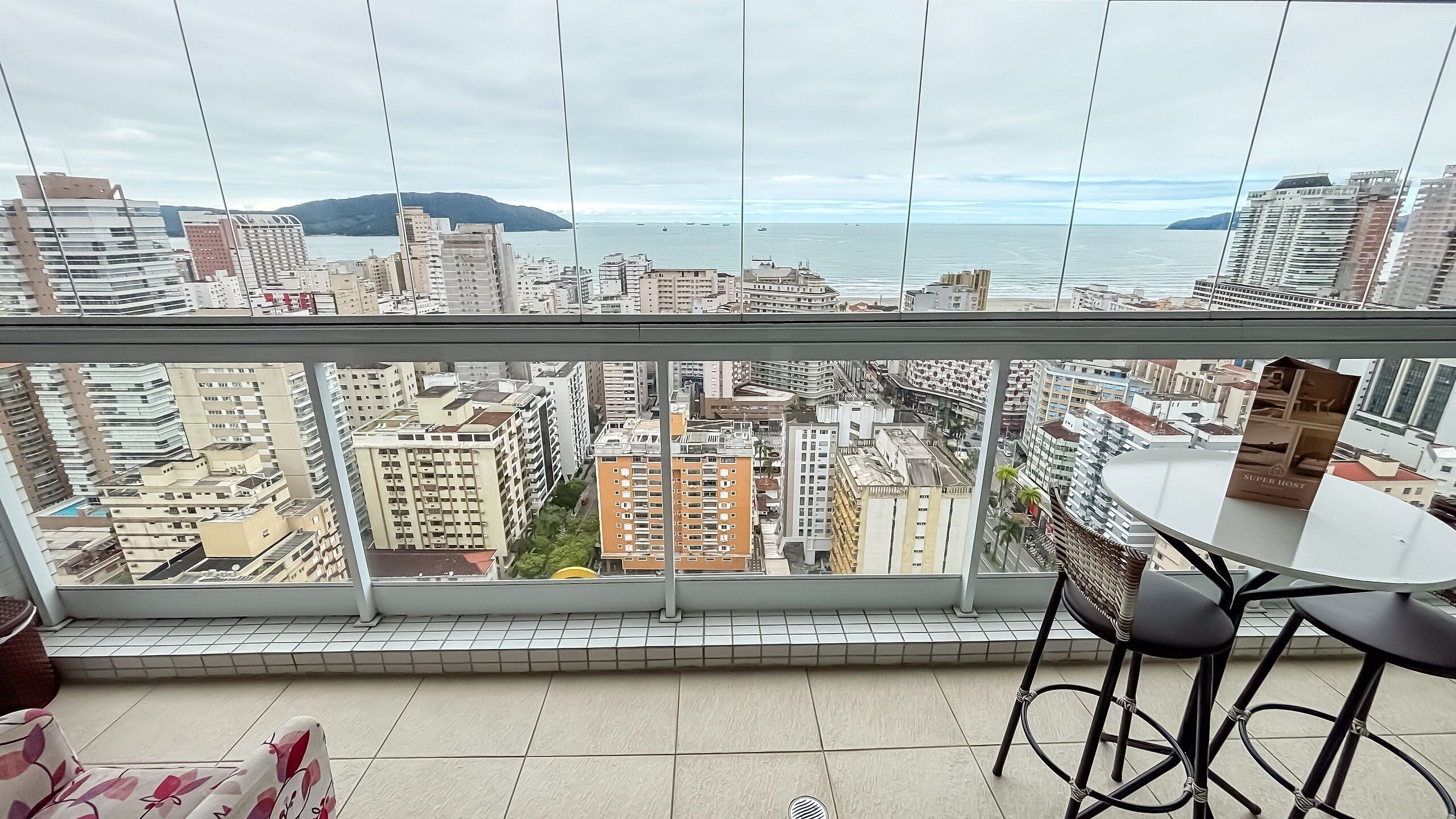 A balcony with a view of a cityscape and the sea.