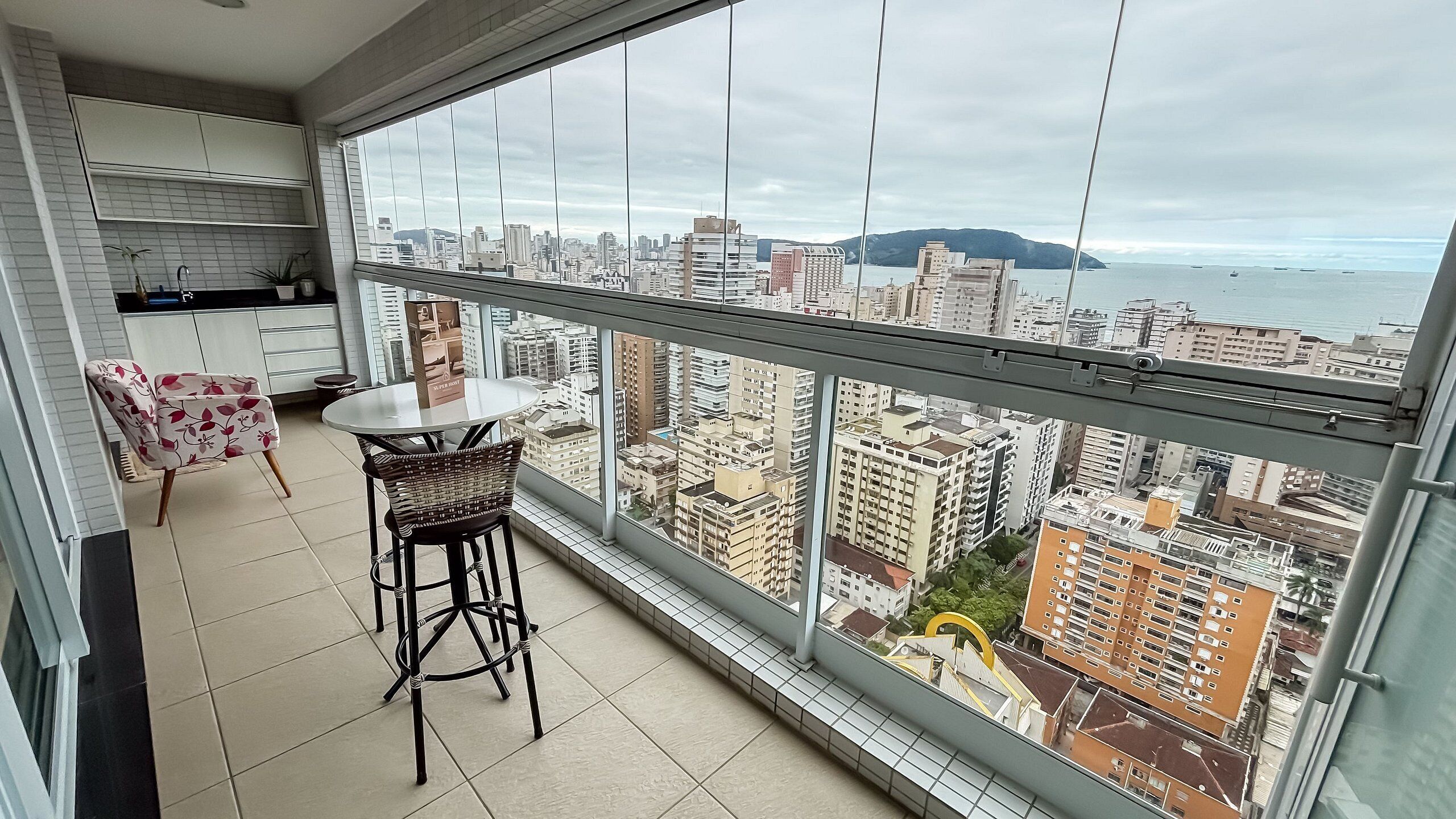 A balcony with a view of a cityscape and ocean.