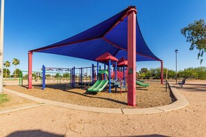 A playground with a shaded area, swings, and slides. - Desert Paradise: Pool, Hot Tub, Sauna & Minigolf (Chandler)