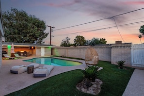 A backyard with a swimming pool, outdoor furniture, and a patio area. - Desert Paradise: Pool, Hot Tub, Sauna & Minigolf (Chandler)
