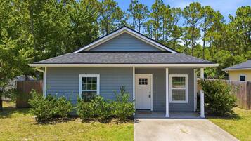 A single-story house with a front porch, a door, and a small window.