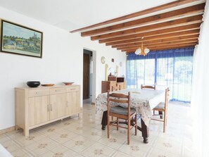 Ein Essbereich mit Holztisch, Stühlen, einem Schrank und einem Bild an der Wand.