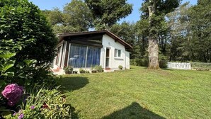 Ein einstöckiges Haus mit geneigtem Dach, einer Haustür und einem Fenster.