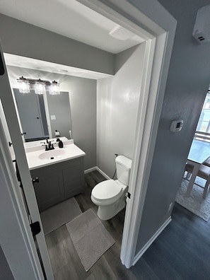 Ein Badezimmer mit Toilette, Waschbecken und Spiegel.