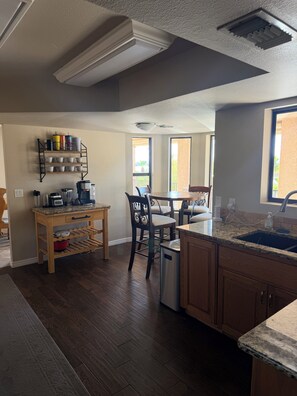 Una cocina con encimera de granito, armarios de madera, horno integrado y ventana con vistas a un balcón.
