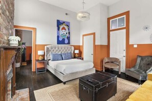 A bedroom with a bed, bedside tables, a dresser, a suitcase, and a chair. - Explore NOLA: Studio 6 Blocks from French Quarter (New Orleans)