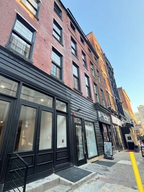 A multi-story building with large windows and a black awning. - Brand New Modern 1BR in Old City Philadelphia (Philadelphia)