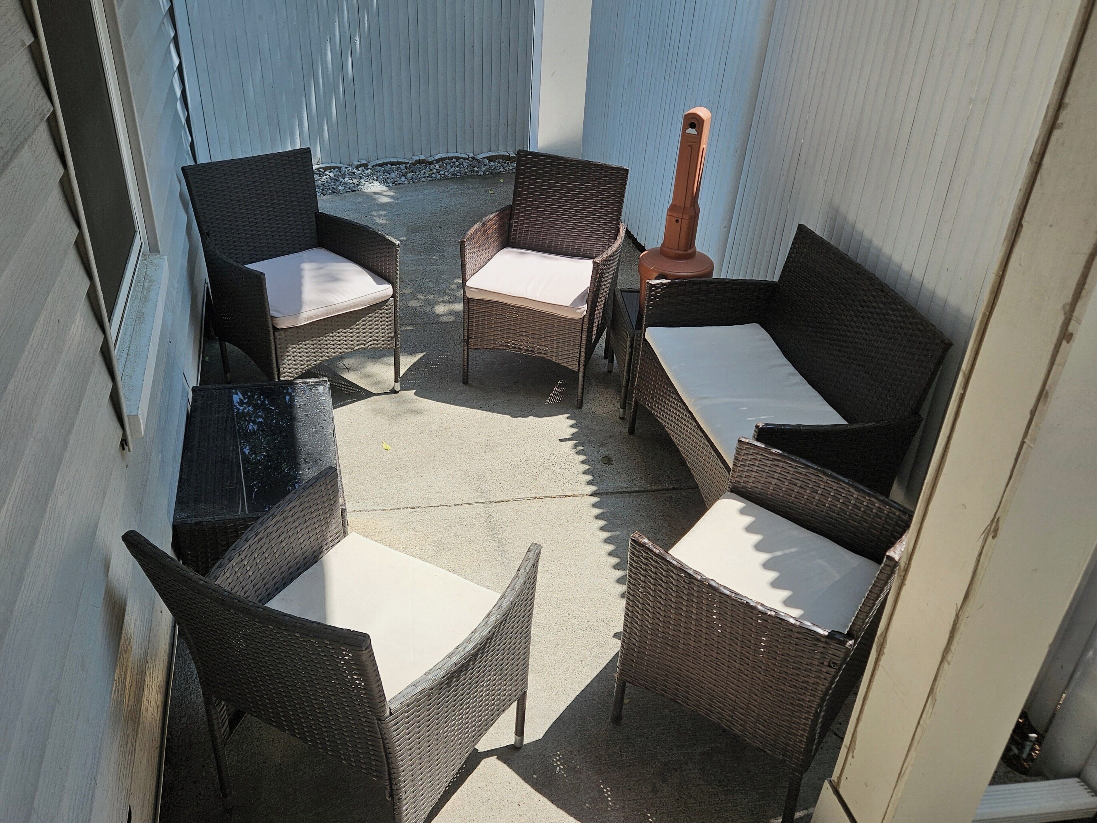 An outdoor seating area with wicker furniture and a table.