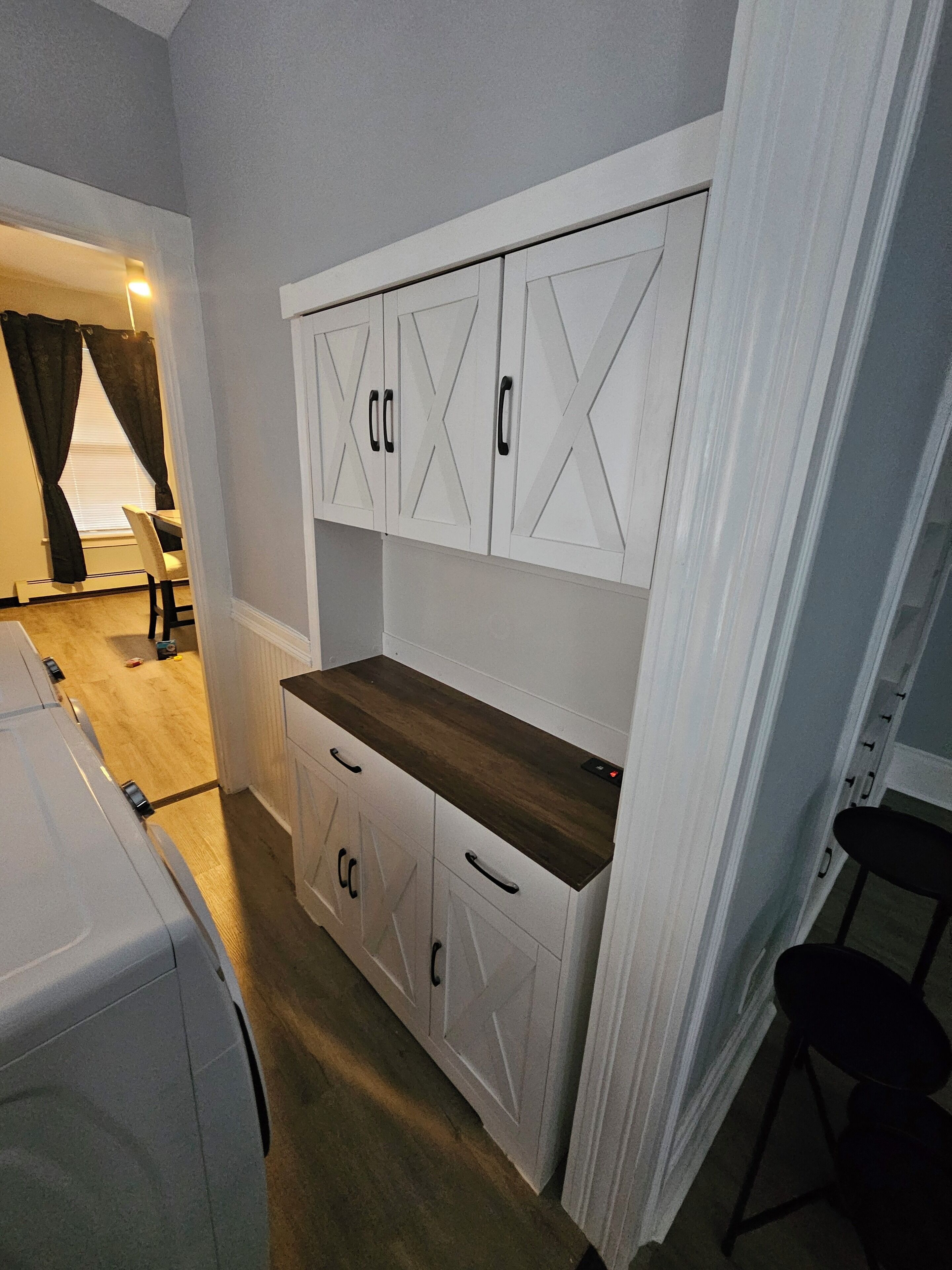 A compact room with a kitchenette area, a bed, and a chair.