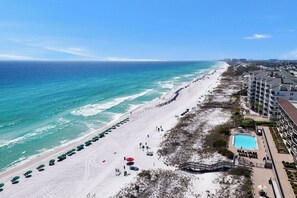 A beach resort with a pool, beach umbrellas, and a view of the ocean. - Tahitian Treasure - Villages of Crystal Beach (Destin)