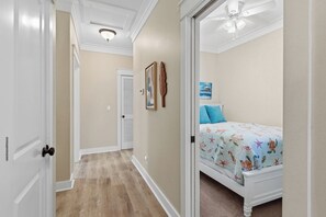 A bedroom with a bed, a ceiling fan, and a door leading to another room. - Tahitian Treasure - Villages of Crystal Beach (Destin)