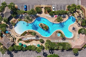 An aerial view of a resort with a large swimming pool, sun loungers, and palm trees. - Tahitian Treasure - Villages of Crystal Beach (Destin)